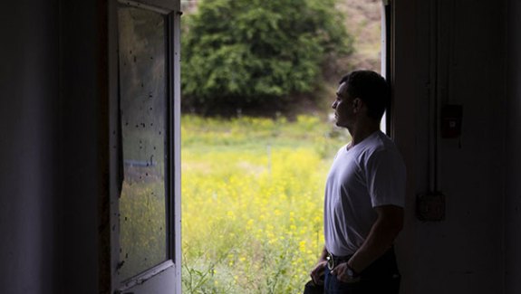 A man standing in an open doorway looking out