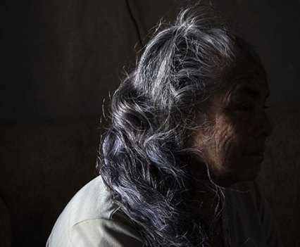 Silhouette of a woman showing long silvery hair.