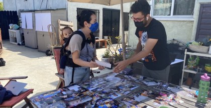 A man and a woman with a young child looking over photo entries