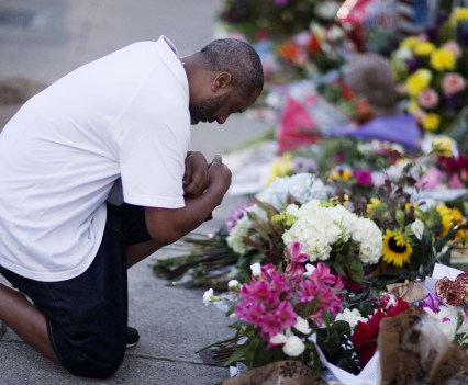 Man kneels at Emanuel AME sidewalk memorial