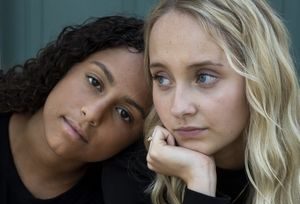 Two girls leaning on each other