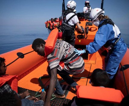 Rescued migrants in lifejackets aboard rescue boat