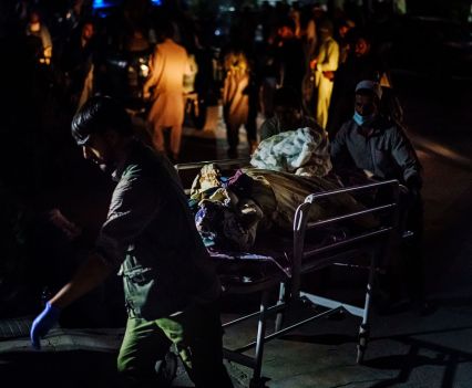 Two people pushing an injured person on a stretcher