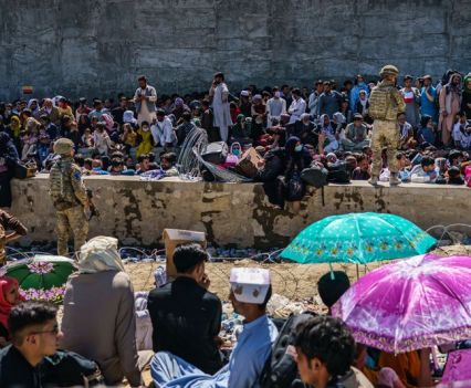 A mass of refugees waiting at Abbey Gate being patrolled by soldiers