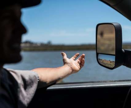 A hand resting on a car window