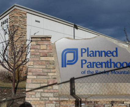 A shadow from a chain link fence falls across the Planned Parenthood of the Rocky Mountains sign.