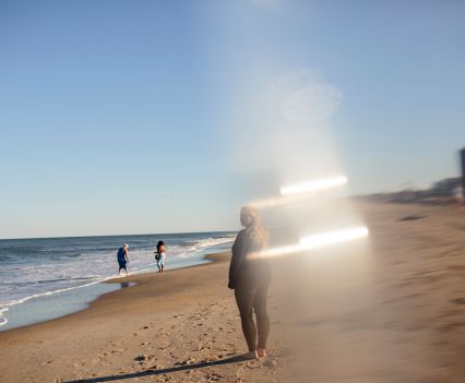 A distorted, broken photo of a young woman on the beach