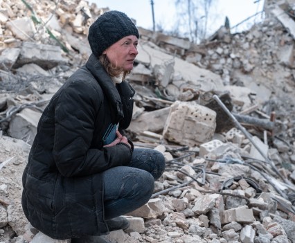 Natalya, resident of the house, watching firefighers working at the rubble of her house in Borodyanka, Ukraine. In the Kyiv suburb of Borodyanka, 29 residential buildings and many more private houses were ruined by Russian airstrikes on March 4 during the battle for Kyiv. According to city officials, there are confirmed bodies of residents under the rubbles. After the Russians retreated, emergency services started to clear rubbles.