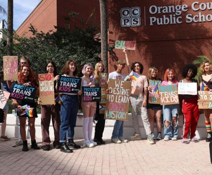 A group of people standing in a row holding signs