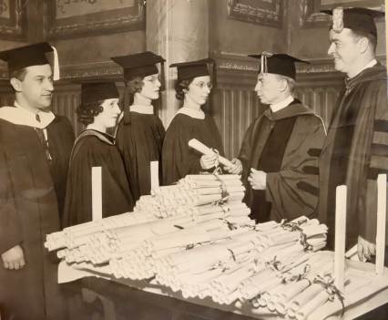 DePaul president Rev. Francis V. Corcoran hands out diplomas to graduating students in 1934. That same year, the University Council, which consulted with and advised Corcoran in major policy issues, detailed the ways in which they discouraged Black students from enrolling. (DePaul Special Collections and Archives)