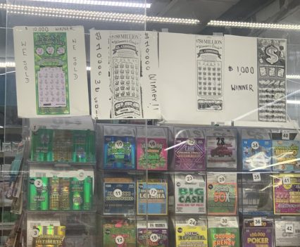 Signs like the one posted above the front counter of a SHOP N Go convenience store in southwest Houston, Texas on May 7, 2022, attract players to buy lottery scratch-off tickets every day. State lotteries spend more than a half-billion dollars a year on messaging like this in pervasive marketing campaigns designed to persuade people to play often, spend more and overlook the long odds of winning. (Hannah Savage/Howard Center for Investigative Journalism)