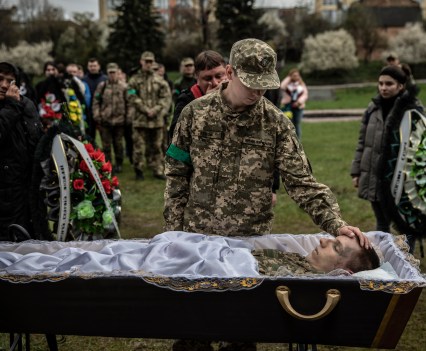 Ukrainian soldier Hlib Kihitov, 21, pays his final respects to his twin brother, Ehor Kihitov, 21, who was killed along with nearly two dozen of his fellow soldiers in an artillery strike in Propasna in the eastern Luhansk region, during his funeral in the western city of Lviv, April 26, 2022.