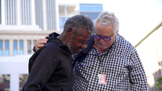 Eddy prays for Mark Horvath as he thanks him for giving him socks