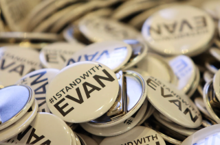 A pile of white pins reading #IStandWithEvan