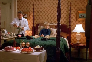 Scene from Home Alone 2 with Kevin in a hotel room enjoying room service, surrounded by desserts.